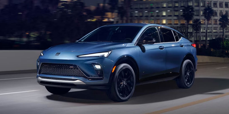 Blue Buick SUV driving on a city road at night
